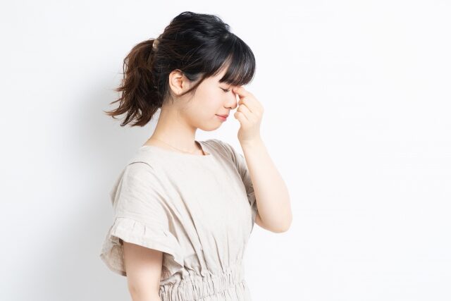 眉間を抑える女性